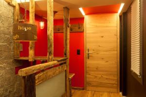 a hallway with a red wall and a door at Schnapskeller in Zermatt