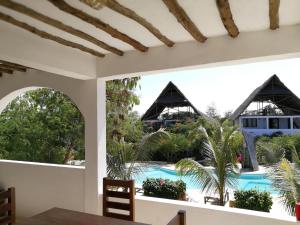 キウェンワにあるBreeze Residence Apartmentsのリゾートのダイニングルームからプールの景色を望めます。