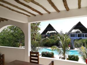 a view of the pool from the dining room of a resort at Breeze Residence Apartments in Kiwengwa