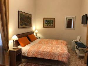 a bedroom with a bed with orange pillows on it at Nori Guest House in Rome