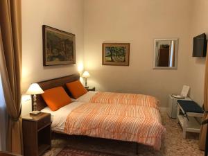 ローマにあるNori Guest Houseのベッドルーム1室(オレンジ色の枕が付いたベッド1台付)