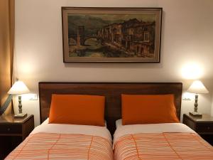 a bedroom with two beds and a painting on the wall at Nori Guest House in Rome