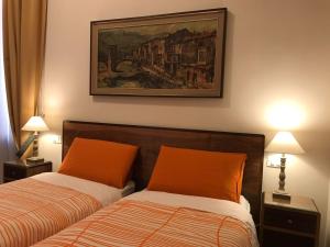 ローマにあるNori Guest Houseのベッドルーム1室(ベッド2台付)が備わります。壁には絵画が飾られています。