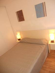 1 dormitorio con 1 cama con 2 luces encendidas en Résidence Goélia Les Chalets de Super-Besse, en Super Besse