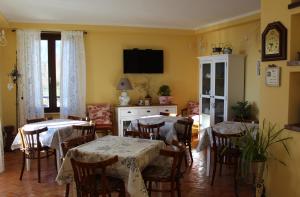 una sala da pranzo con tavoli, sedie e TV di Le Fiorini a Gargnano