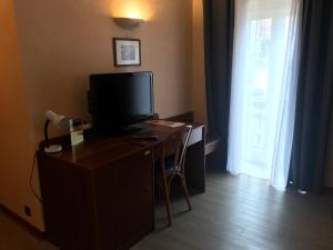 Televiisor ja/või meelelahutuskeskus majutusasutuses Hôtel Vesuvio