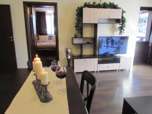 a living room with a table with wine glasses and a television at Bavaria House in Govedartsi +32 photos