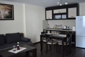 a living room with a table and chairs and a kitchen at Bavaria House in Govedartsi
