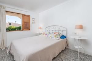 um quarto branco com uma cama branca e uma janela em Villa EL LAGO ALCUDIA em Alcudia