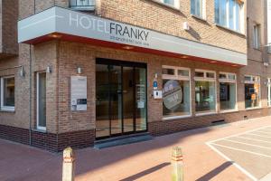 
a man standing outside of a store on a sidewalk at Hotel Franky in Blankenberge
