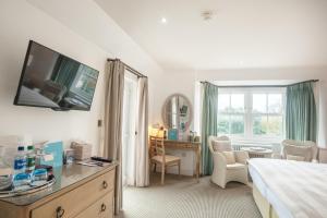 a bedroom with a bed and a desk and a window at Sidmouth Harbour Hotel & Spa in Sidmouth