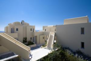 
a white building with a white roof and a blue sky at The Majestic Hotel in Fira
