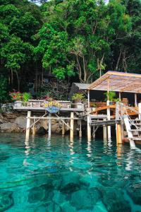 a dock with a house and the water at Iboih inn in Sabang