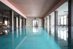 克萊恩 蒙塔納的住宿－克萊恩大使酒店，蓝色瓷砖建筑中的游泳池