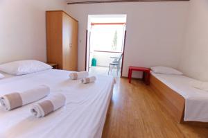 two beds in a room with white sheets at Slanica studio ID 816 by HeartofDalmatia in Murter