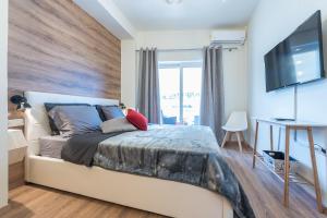 Un dormitorio con una cama grande y un televisor de pantalla plana. en Athenz Downtown Studio, en Atenas