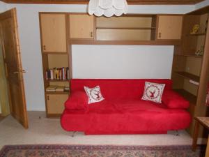 a red couch with two pillows on it in a room at La vecchia Mesnerhaus in Pusterwald