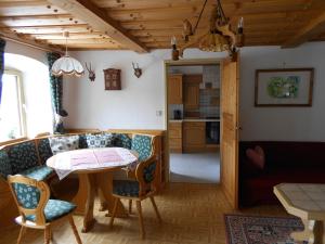 a living room with a table and chairs and a kitchen at La vecchia Mesnerhaus in Pusterwald