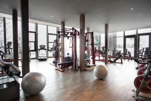 a gym with exercise equipment in a building with windows at Crans Ambassador in Crans-Montana