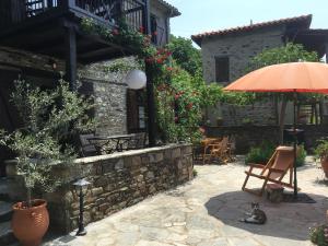 a patio with an umbrella and a table and chairs at Charming Stone House in Parthenonas