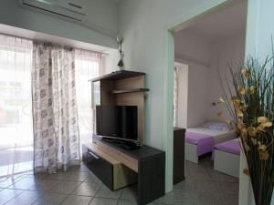 a room with a tv on a desk with a bedroom at More in Malinska