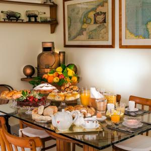 ソレントにあるYacht Club Capo Cervo Suites B&Bのテーブル(食べ物とオレンジジュースの朝食付)
