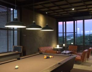 a pool table in a large room with windows at Inchantreedoopool in Kanchanaburi City