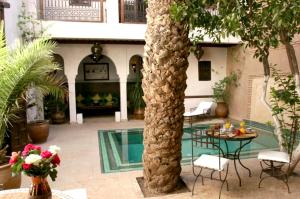 un patio con una palmera y una piscina en Riad Palmier, en Marrakech