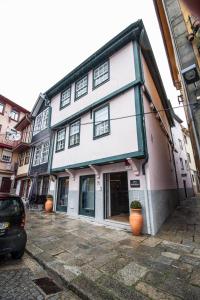 un edificio blanco con macetas naranjas delante de él en Miragaia House, en Oporto