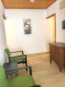 a living room with two chairs and a wooden table at Hostal Casa Torrent in Canet de Mar