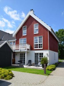 Fewo Kleine Brise Greetsiel في غريتسيل: بيت احمر وبيض مع كرسيين