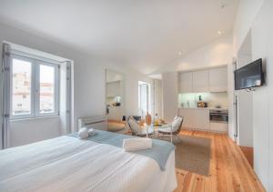 里斯本的住宿－Canaan Lifestyle Apartments Lisbon Combro 77 by Get Your Stay，一间白色卧室,配有一张大床和一个厨房