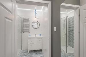 y baño blanco con lavabo y ducha. en Loretańska Apartments 6, en Cracovia