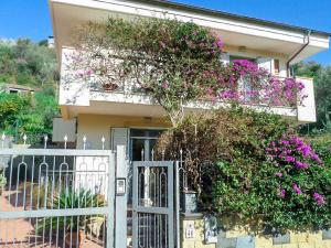 una casa con cancello bianco e fiori viola di Dolce Casa n41 a Savoca