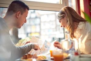 un homme et une femme assis à une table qui mangent de la nourriture dans l'établissement WestCord City Centre Hotel, à Amsterdam