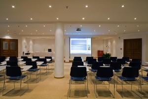 a large room with rows of chairs and a large screen at The Majestic Hotel in Fira