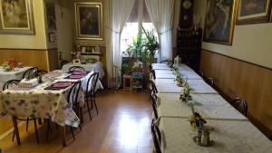a room with four tables with white tablecloths at Pensione Santachiara in Sanremo