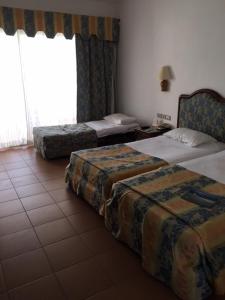 Holiday Rooms Domina Coral Bay tesisinde bir odada yatak veya yataklar