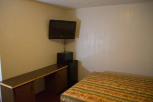 um quarto com uma cama e uma televisão de ecrã plano em Tazewell Motor Lodge em Tazewell