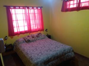ein Schlafzimmer mit einem Bett und roten Fenstern in der Unterkunft Casas del Mar in San Bernardo + 25 Fotos