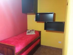 ein kleines Zimmer mit einer roten und gelben Wand in der Unterkunft Casas del Mar in San Bernardo