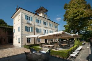 a building with tables and umbrellas in front of it at Villa Tiboldi in Canale