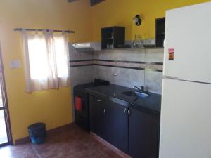 eine Küche mit Spüle und einem weißen Kühlschrank in der Unterkunft Casas del Mar in San Bernardo