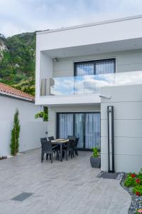 ein Haus mit einer Terrasse mit Tisch und Stühlen in der Unterkunft RR House in Ribeira Quente