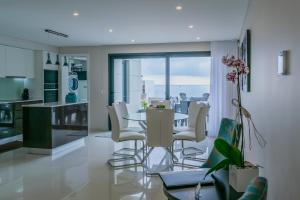 eine Küche und ein Esszimmer mit Tisch und Stühlen in der Unterkunft RR House in Ribeira Quente