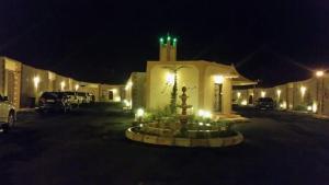 a building with a fountain in front of it at night at Taraf Al Asalah Villas in An Nimāş