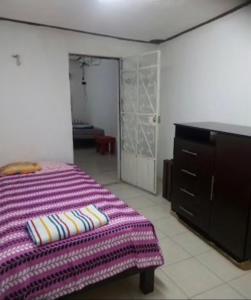 a bedroom with a bed and a dresser and a closet at Casa Colonial Centro in Mérida