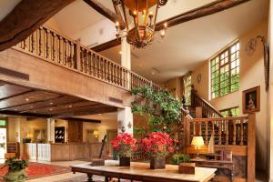 a large room with a staircase and a table with flowers at Le Manoir de Gressy in Gressy