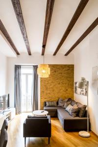 salon z kanapą i ceglaną ścianą w obiekcie Travel Habitat Jardines Rio Turia. w Walencji