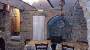 Borgo La Forgia في Roccasicura: غرفة طعام مع طاولتين وجدار حجري